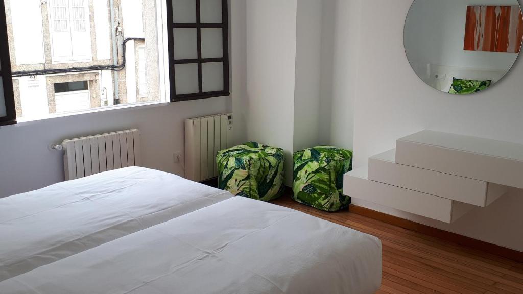 a bedroom with a bed and a dresser at PR Blanco in Santiago de Compostela