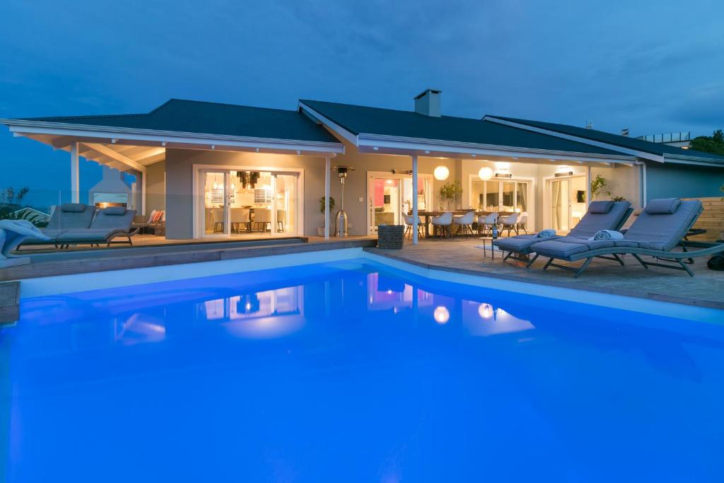 a house with a swimming pool in front of a house at CM34 - Pezula Heaven On Earth in Knysna