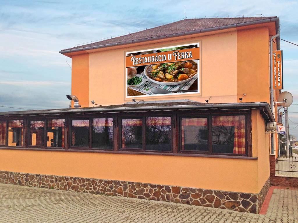 a restaurant with a sign on the side of a building at U Ferka in Lemešany