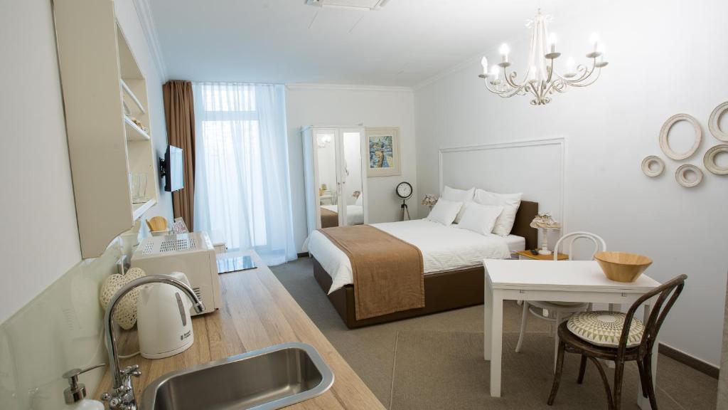 Cette chambre comprend un lit, une table et un lavabo. dans l'établissement Regal Residence B&B, à Zagreb