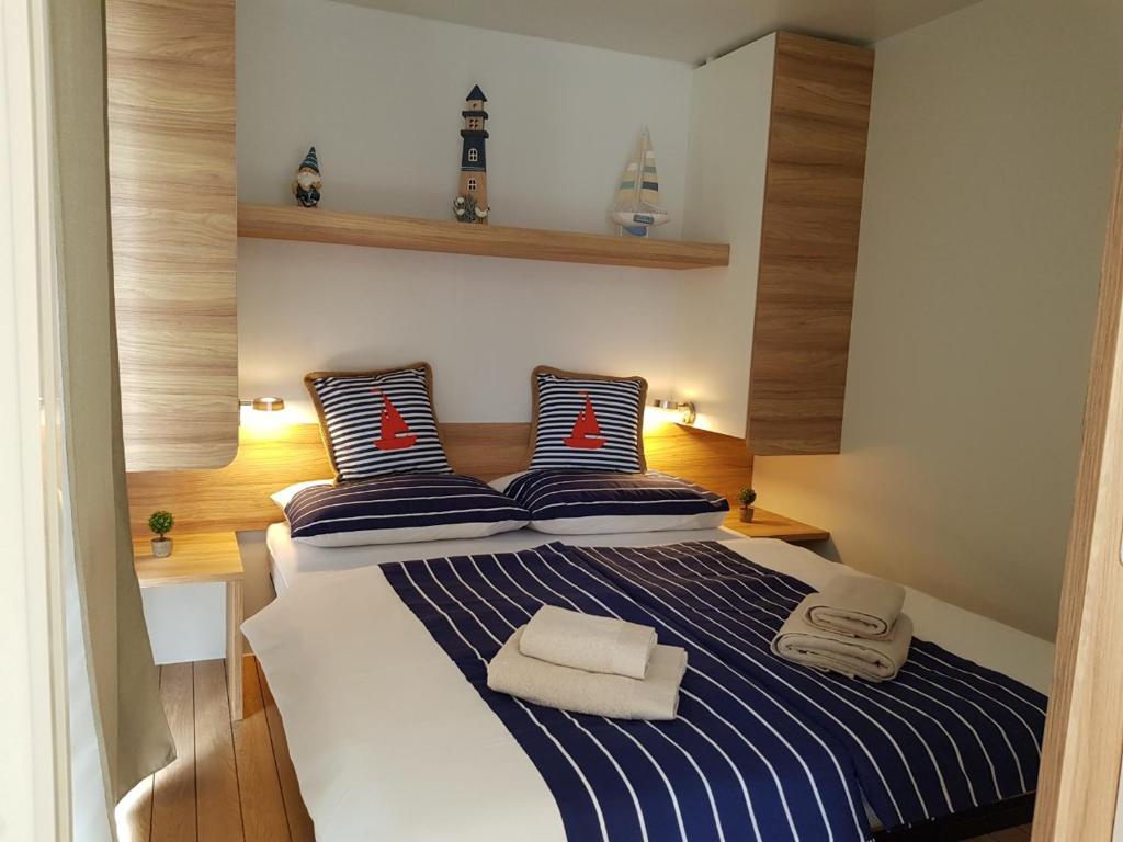 a bedroom with a bed with blue and white stripes at Mobile Home Camping park Soline Gapi house in Biograd na Moru