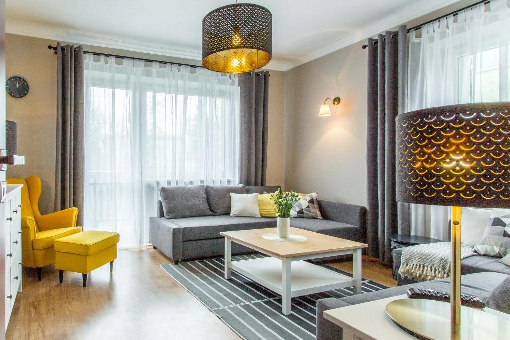 a living room with a couch and a table at Apartament Bulwary Zakopane in Zakopane