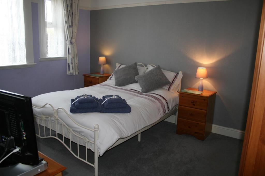 a bedroom with a bed with two blue towels on it at The Ryecroft in Great Yarmouth