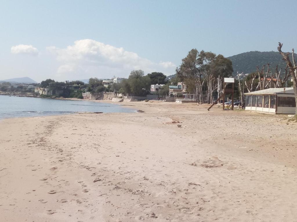 une plage avec des empreintes de pieds dans le sable à côté de l'eau dans l'établissement Vangelis House near Athens Airport, à Artemi
