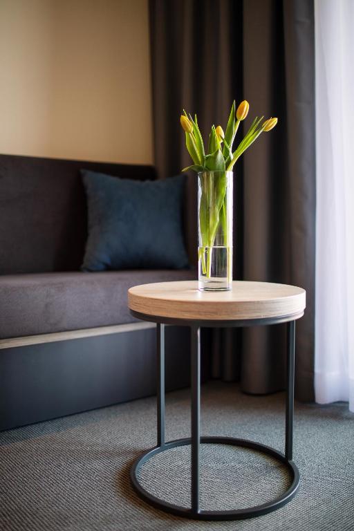 a vase with flowers on a table in a living room at Dependences - San Simon Resort in Izola
