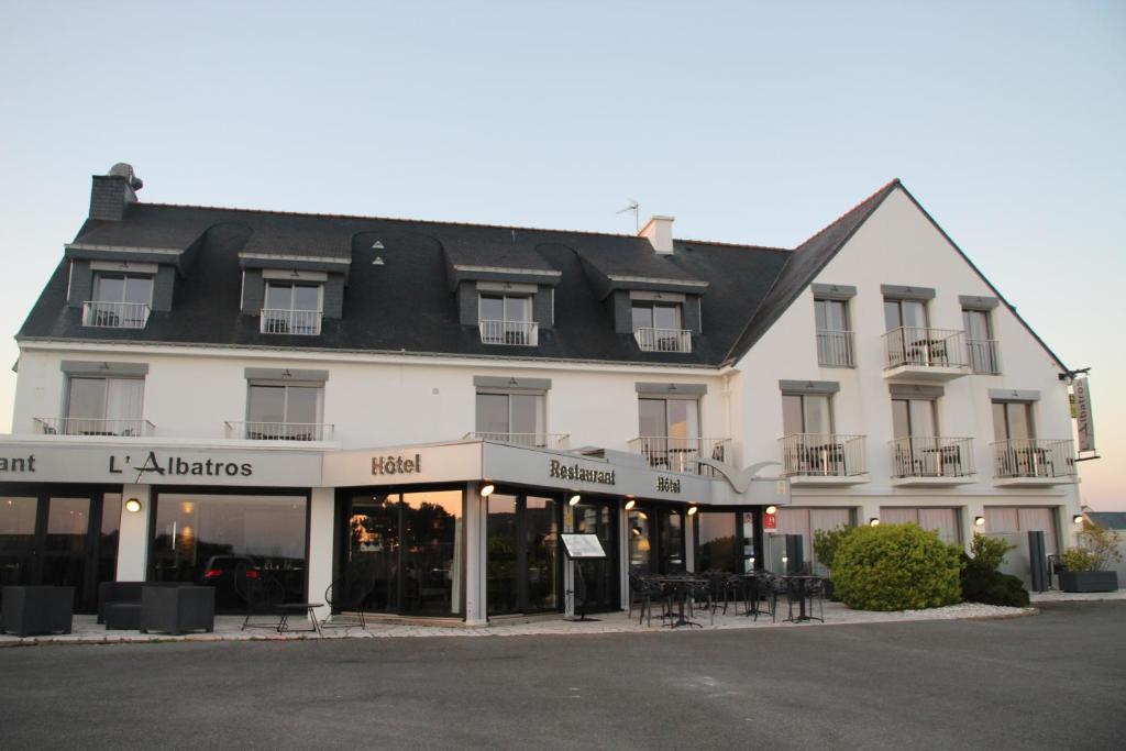 un grand bâtiment blanc avec un toit noir dans l'établissement Hôtel l'Albatros, à Damgan