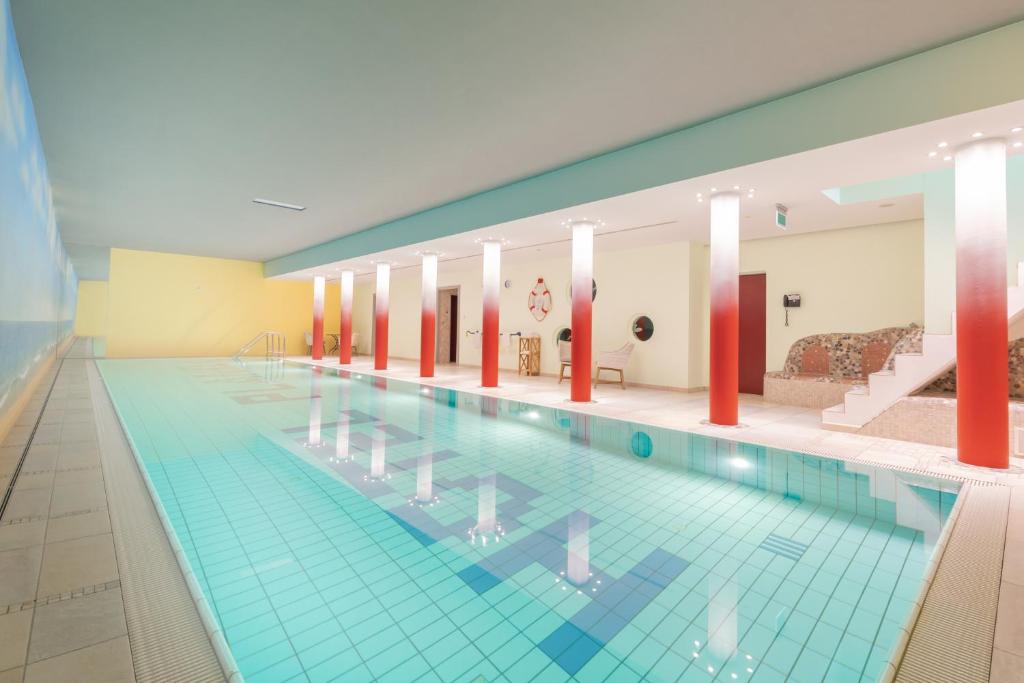 a large swimming pool in a large building at Bavaria Lifestyle Hotel in Altötting