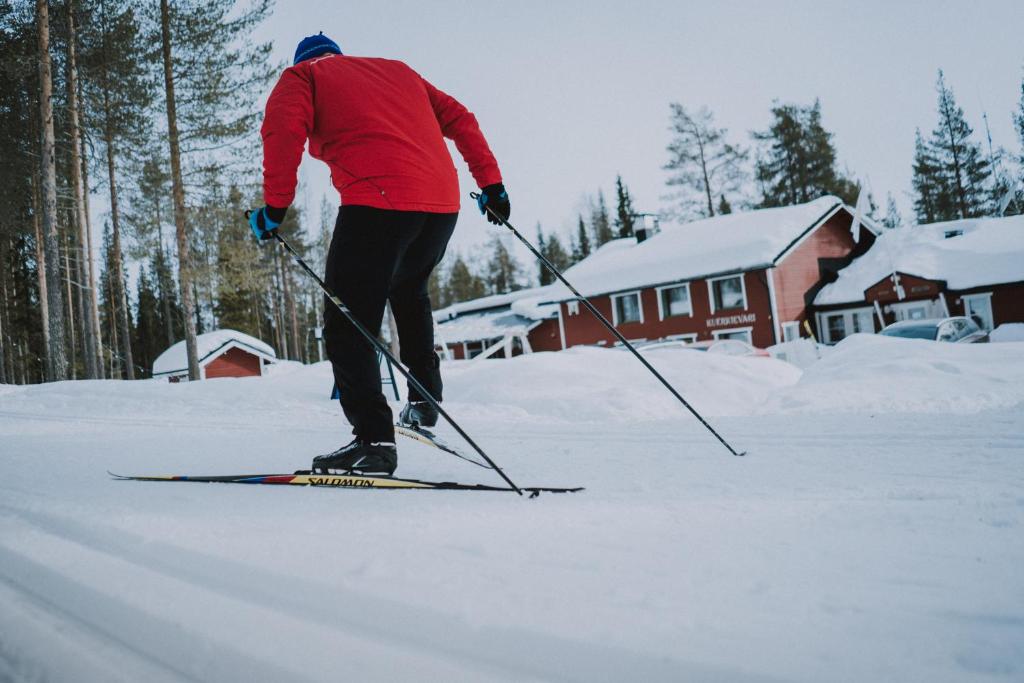 een man is op ski's in de sneeuw bij Kuerkievari KuerHotel in Äkäslompolo