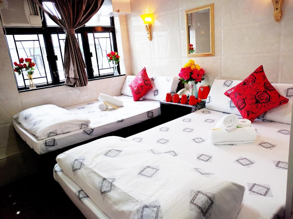 two beds in a room with red and white pillows at Pacific Lodge Reception 10th Floor Block D in Hong Kong