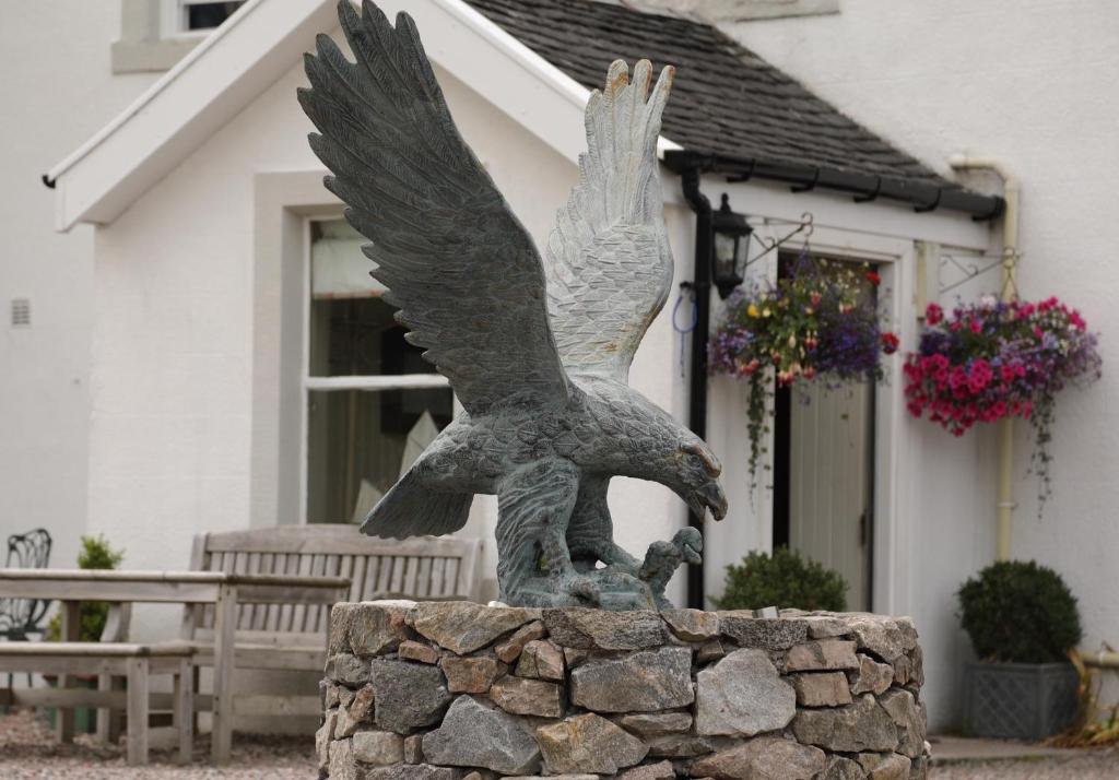 
a statue of a bird sitting on top of a rock at Kilcamb Lodge Hotel in Strontian
