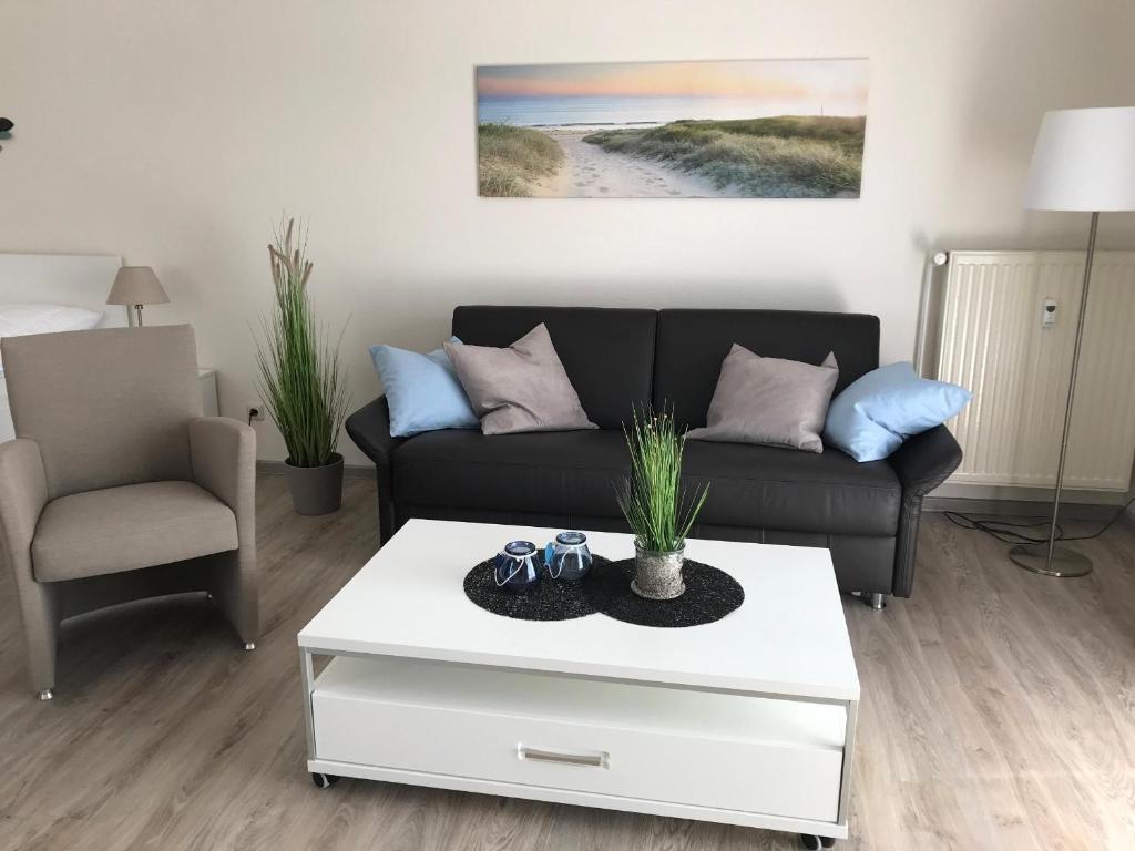 - un salon avec un canapé noir et une table basse blanche dans l'établissement Steiner Strandappartements Appartement 110 Südseite mit seitlichem Meerblick, à Stein