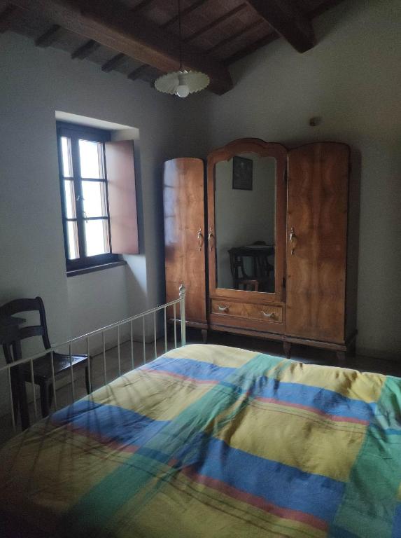a bedroom with a large bed and a dresser at La Corte di Nonna Quercia in Cagli