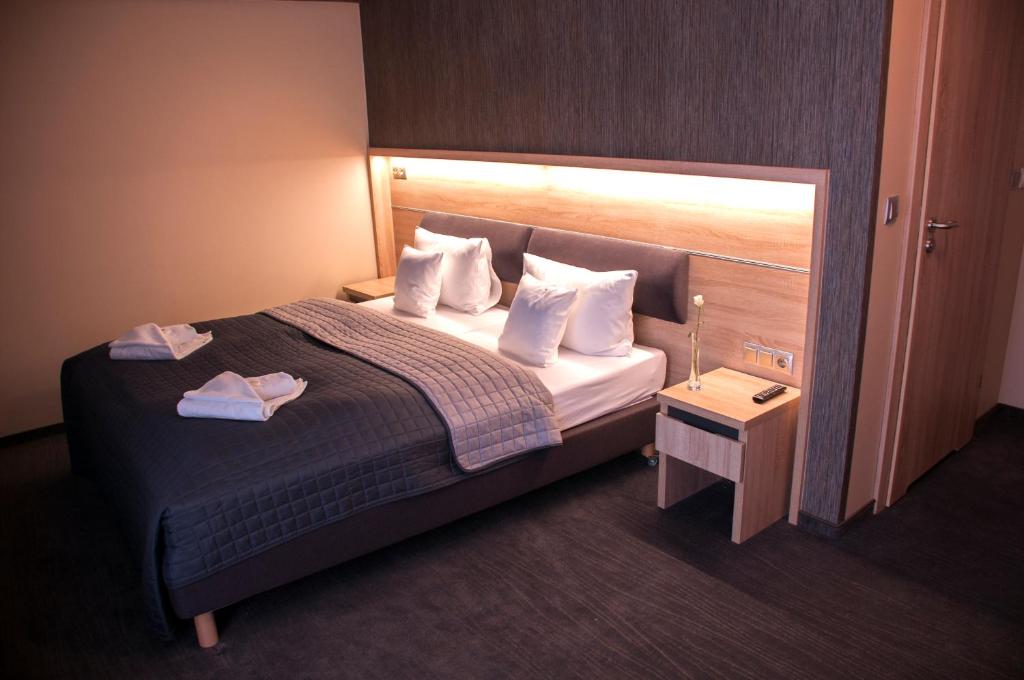 Pokój hotelowy z łóżkiem z białymi poduszkami w obiekcie Hotel Jakuszyce Sport & Spa w Szklarskiej Porębie