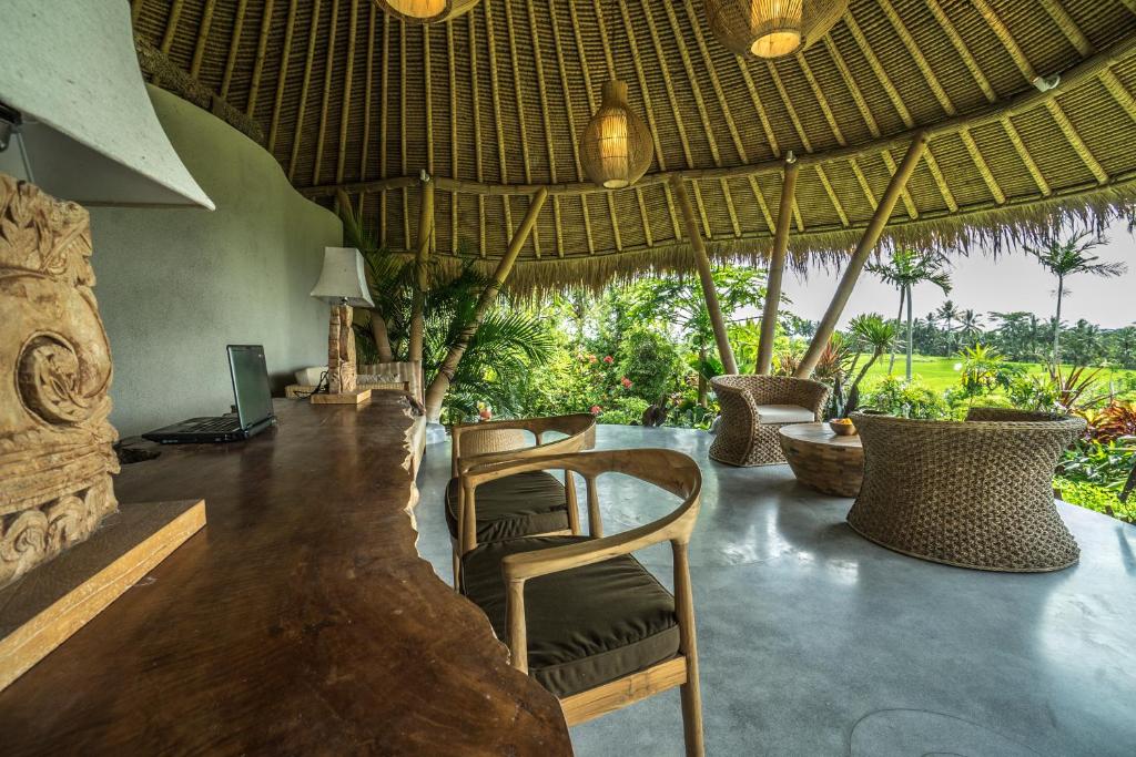 a room with chairs and a television in a resort at Malaya Villas Ubud in Ubud