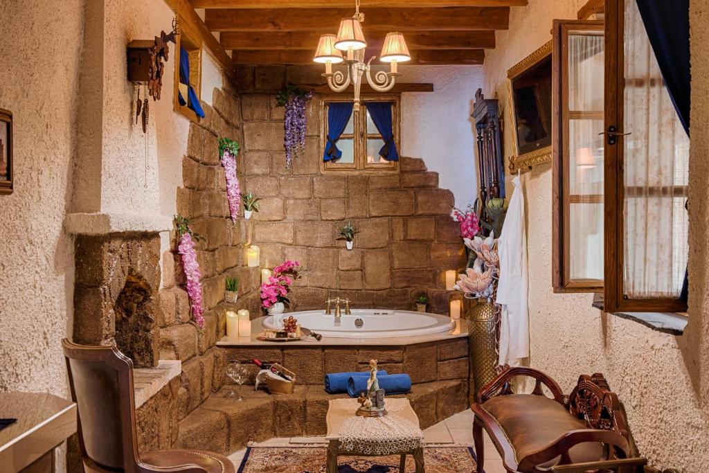 a bathroom with a tub in a stone wall at Koukos Rhodian Guesthouse - Adults Only in Rhodes Town