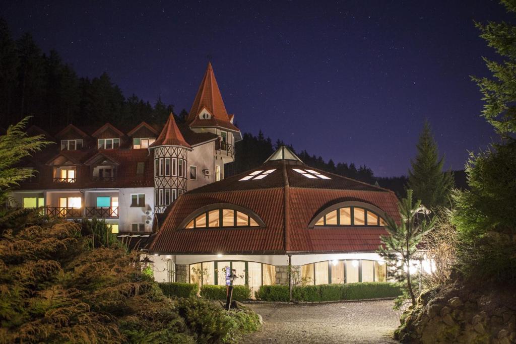 Hotel complex illuminated at night with turret and starry sky, peaceful evening ambience