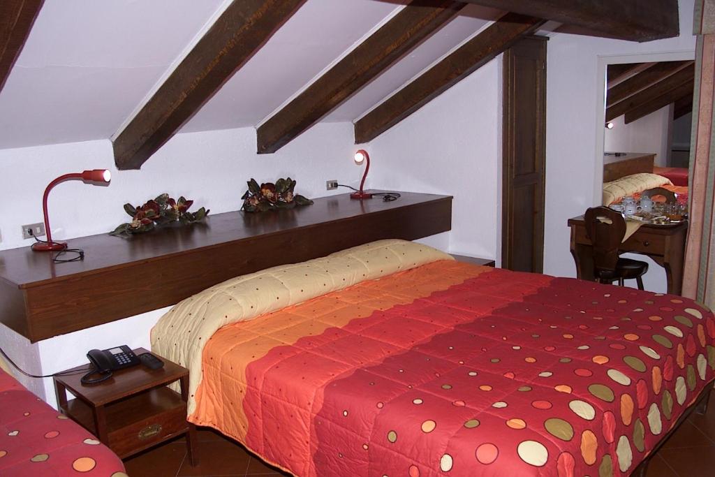 a bedroom with a bed with a red comforter at Hotel Biancaneve in Sestriere