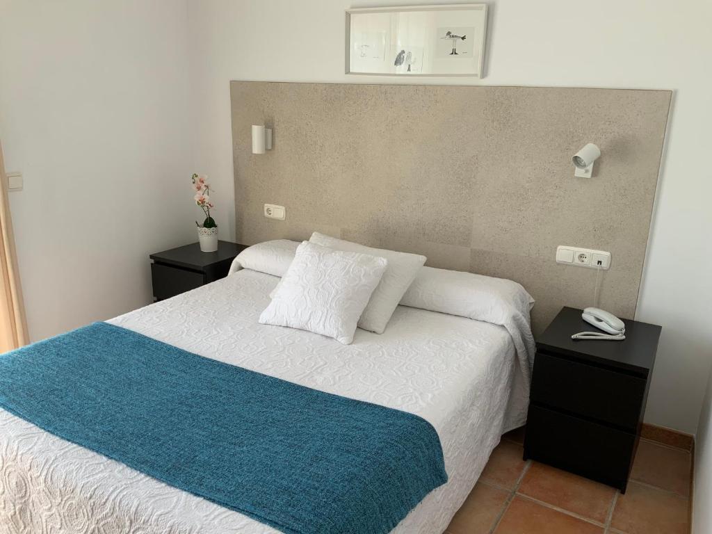 a bedroom with a bed with a blue and white blanket at Santuario San José in San José