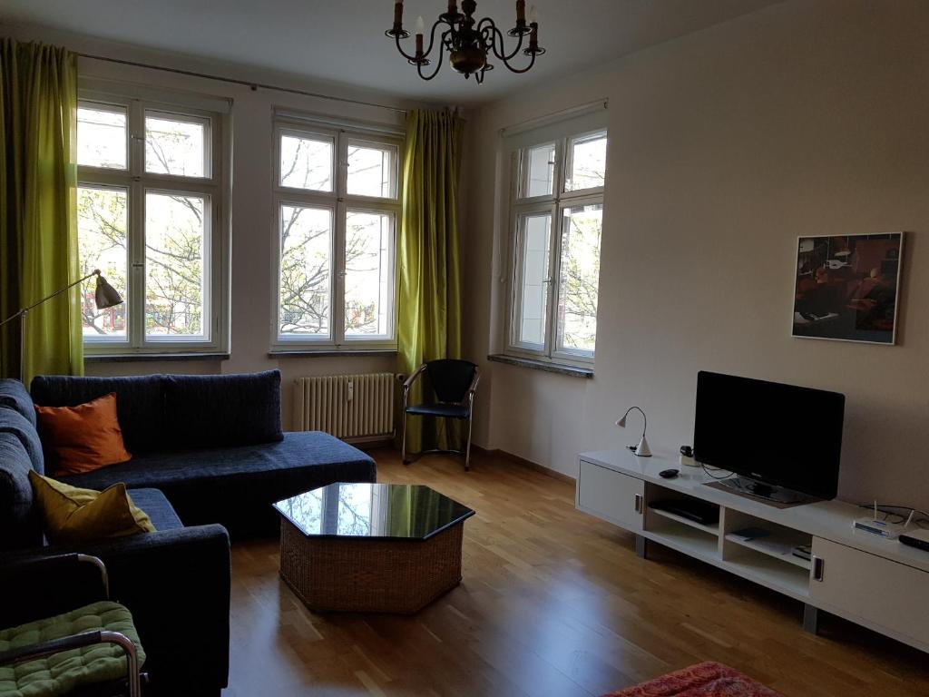 - un salon avec un canapé et une télévision dans l'établissement Frankfurter Tor, à Berlin