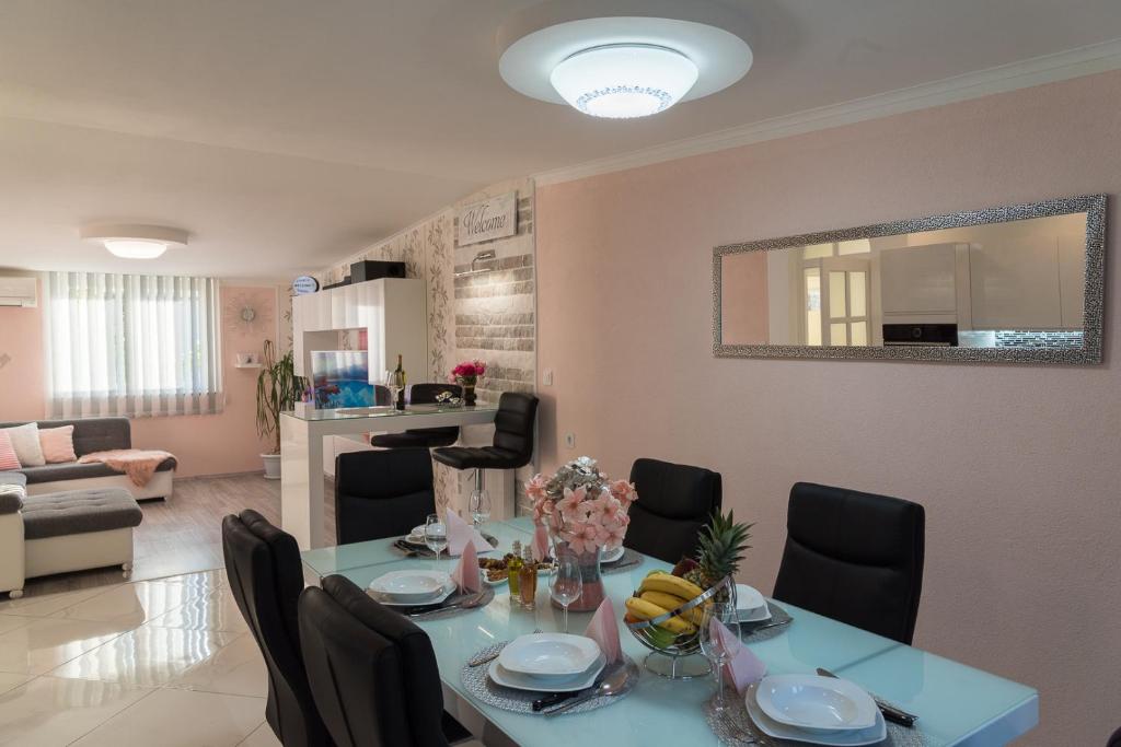 a dining room and living room with a table and chairs at Apartment Danijela II in Šibenik