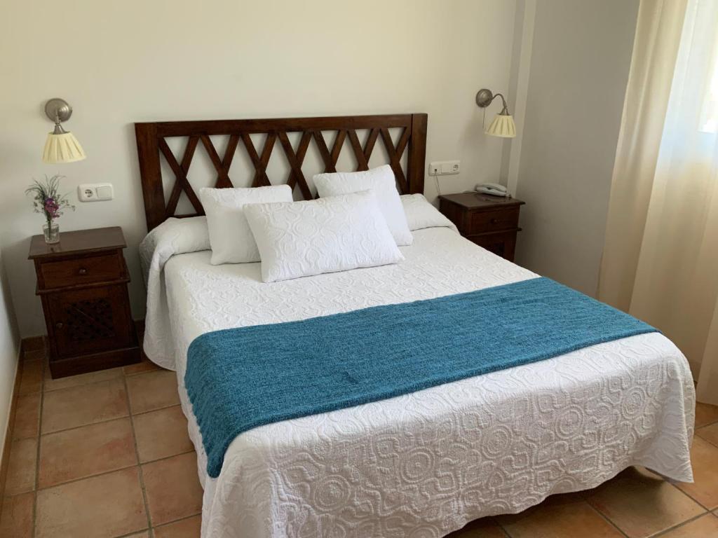 a bedroom with a large bed with a blue blanket at Santuario San José in San José