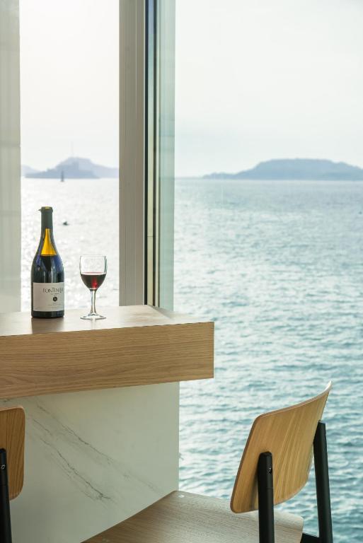 a glass of wine sitting on a table next to a window at Les Bords De Mer in Marseille