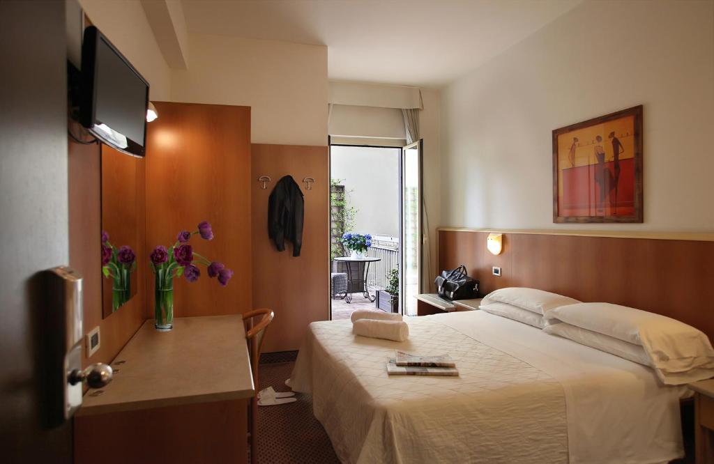 um quarto de hotel com uma cama e uma televisão em Hotel Principe di Piemonte em Rimini