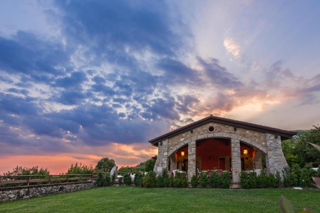 a stone house with a sunset in the background at SarAnd Relais-Adults Only in Fondi
