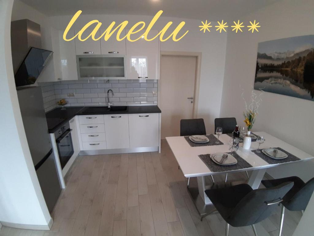 a kitchen with a dining table and a kitchen with a sink at LANELU apartman in Rogoznica