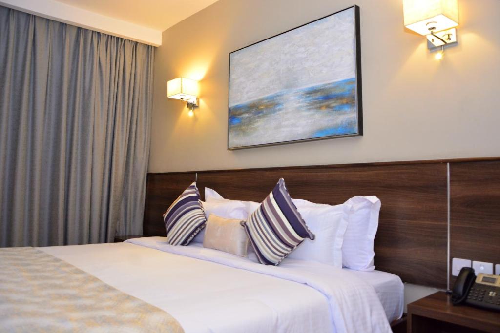 a hotel room with two beds and a tv on the wall at Razana Hotel in Nairobi