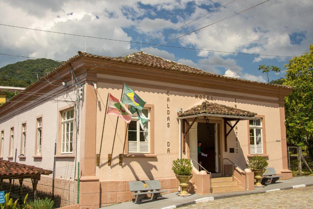 a small pink house with two flags in front of it at Hotel Caldas da Imperatriz in Santo Amaro da Imperatriz