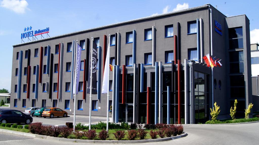 un gran edificio con banderas delante en Hotel Malinowski Business, en Gliwice