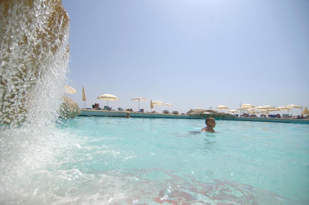 a child in a swimming pool with a fountain at The Preluna Hotel in Sliema