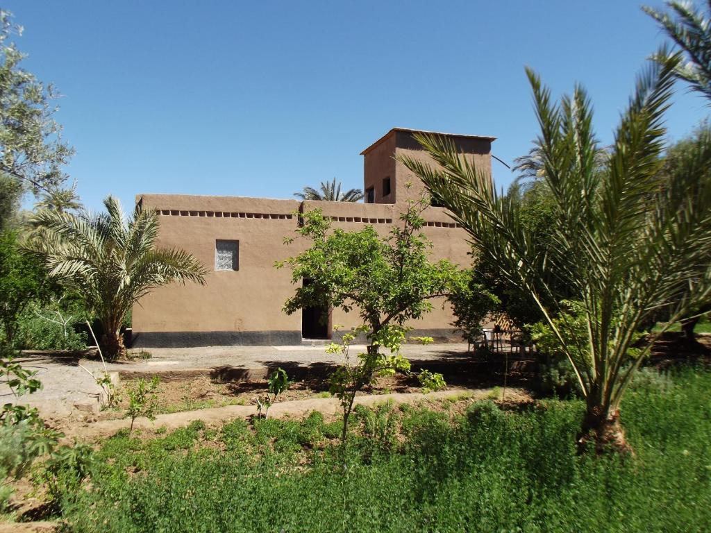 a building with palm trees in front of it at LE JARDIN DES GRENADIERS in Skoura
