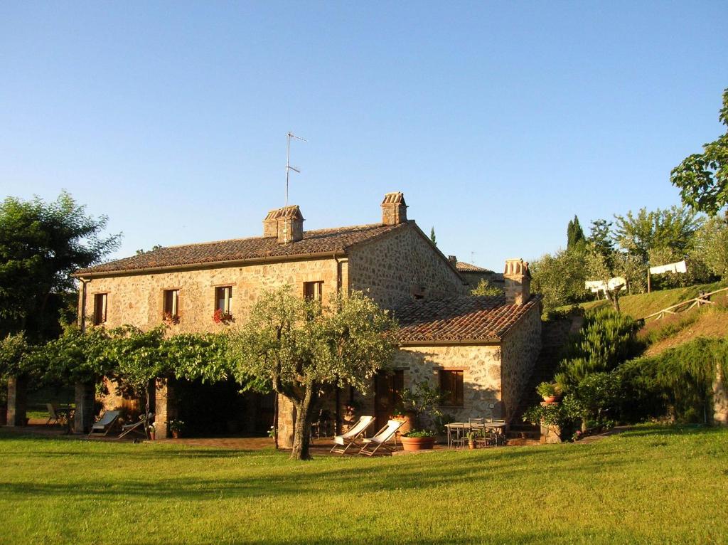 een oud stenen huis op een grasveld bij La Chiusetta in Orvieto