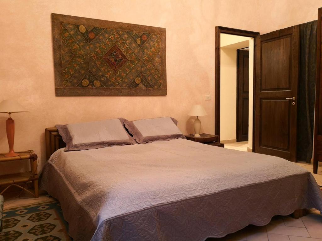 una camera da letto con un letto e un dipinto sul muro di San Giovannina '800 a Casale Monferrato