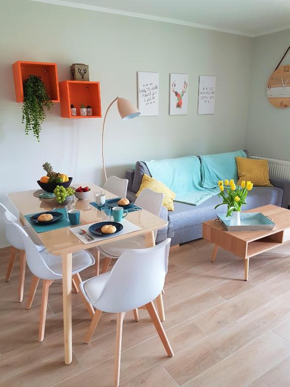 a living room with a table and a couch at Apartament MOMENTUM in Trzęsacz