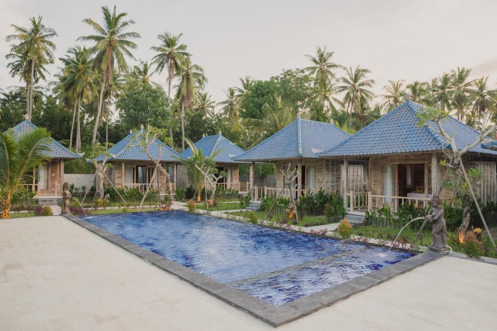 a villa with a swimming pool in front of a house at Kayuna Villa in Nusa Penida