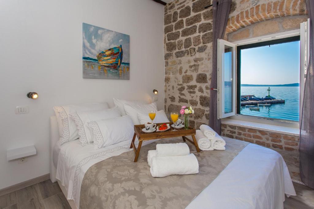 a bedroom with a large bed and a large window at Seafront apartment in historical Cippico castle in Kaštela