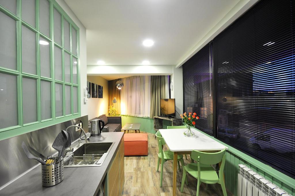a kitchen with green cabinets and a table and a dining room at Modern Apartments in Tbilisi City