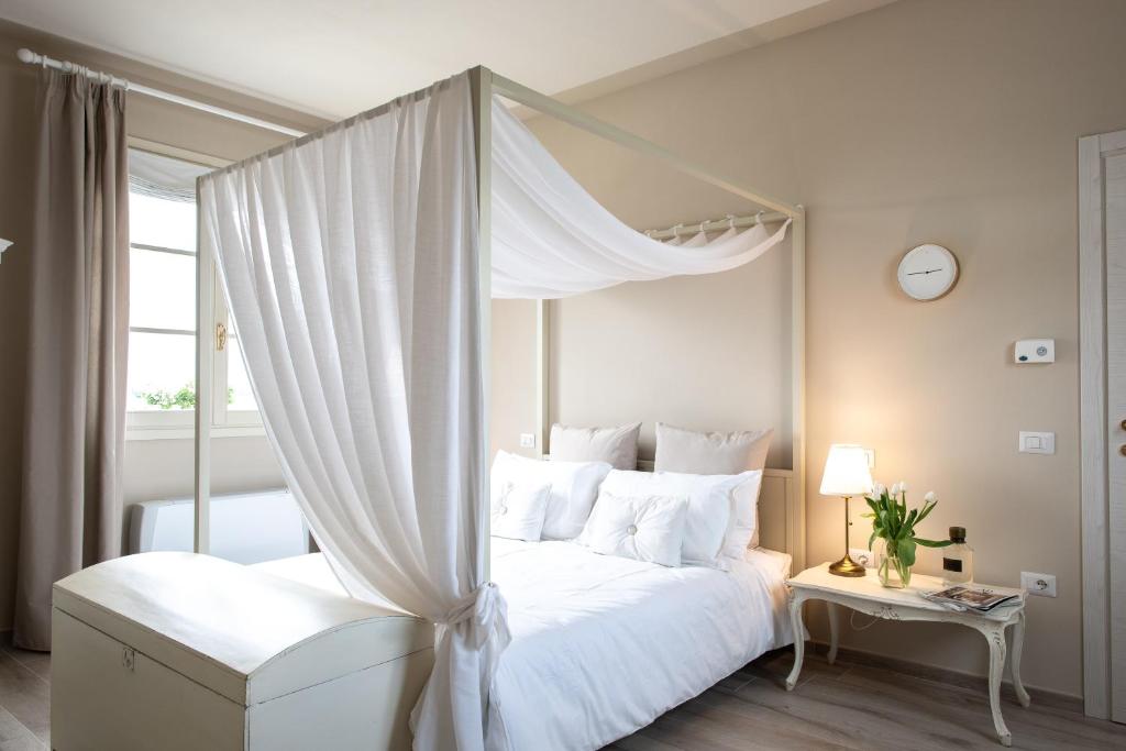 a bedroom with a white bed with a canopy at La Locanda di Corrado in Cerreto Guidi