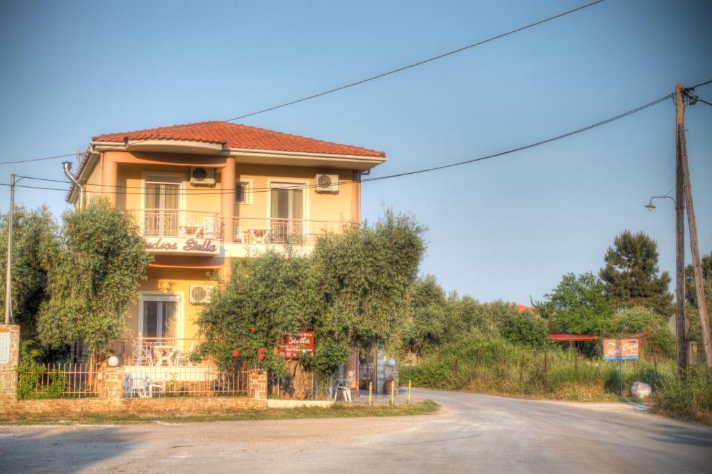 a yellow house on the side of a road at Studios Stella in Skala Potamias