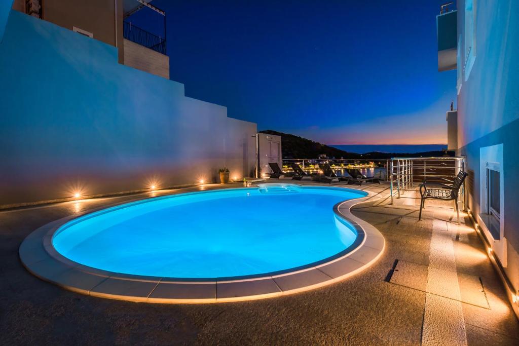 uma piscina à noite com um edifício em Villa Mirta em Tisno