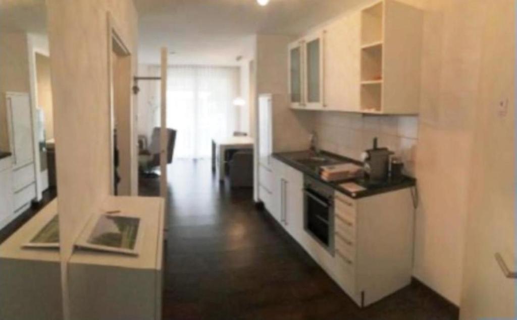 a kitchen with white cabinets and a stove top oven at Wellness- & Golf-Appartement 2.2 Hebelhof in Bad Bellingen