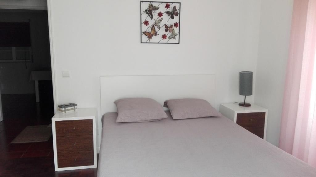 ナザレにあるApartamento Nazaréのベッドルーム1室(白いベッド1台、枕2つ付)