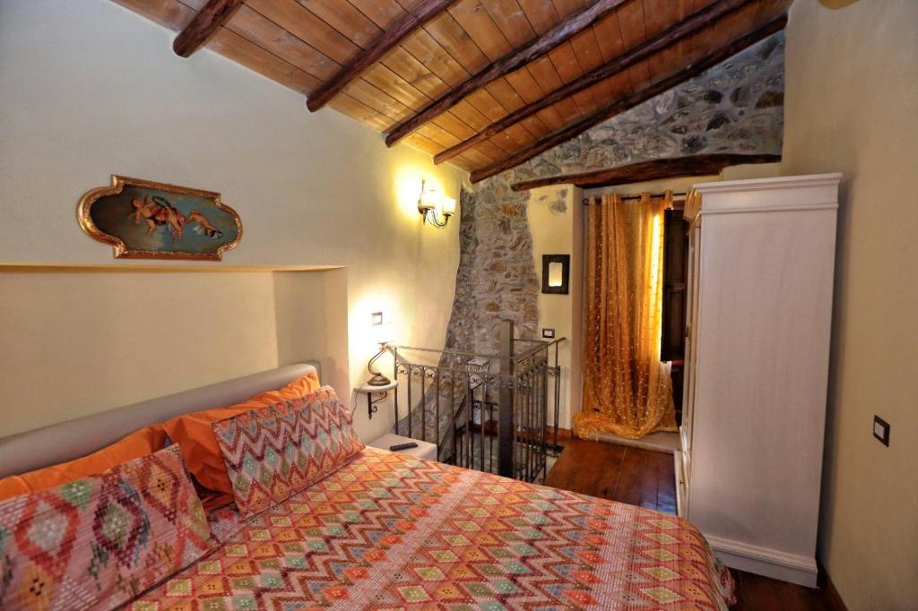 a bedroom with a bed with an orange comforter at Al Castello in Brolo