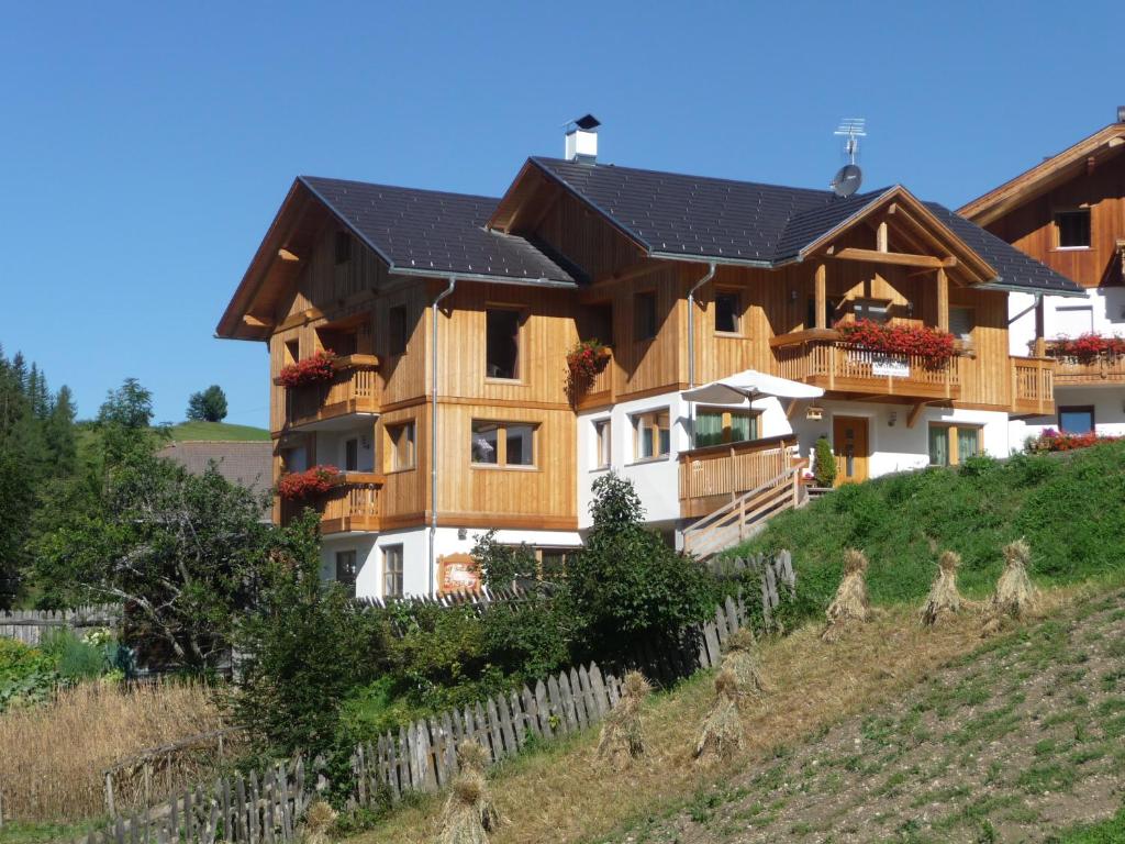 una gran casa de madera en una colina en Apartments Rit, en La Valle