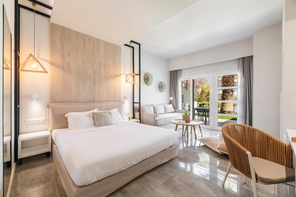 a bedroom with a bed and a living room at Minthi Boutique Apartments in Hanioti