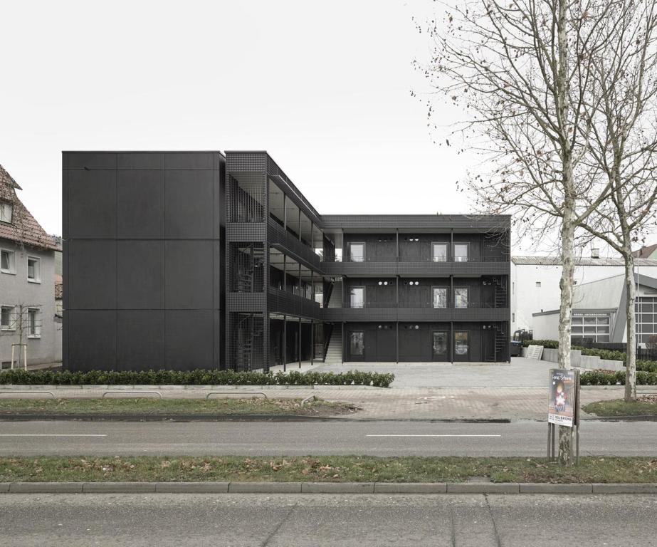 un bâtiment noir sur le côté d'une rue dans l'établissement NewAge Boardinghaus N70, à Heilbronn