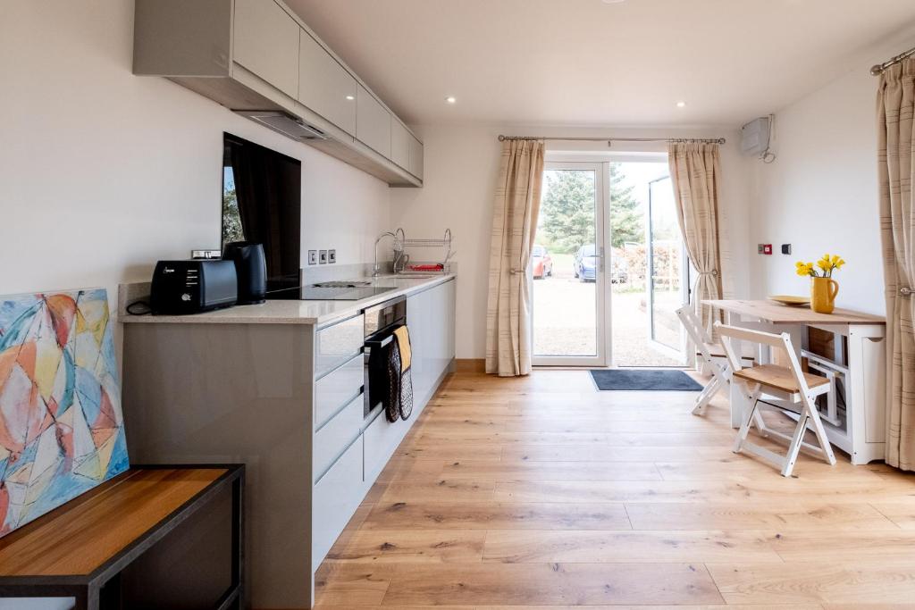 a kitchen with a counter and a table and a counter top at Maple – Three Tuns Apartments in Pettistree